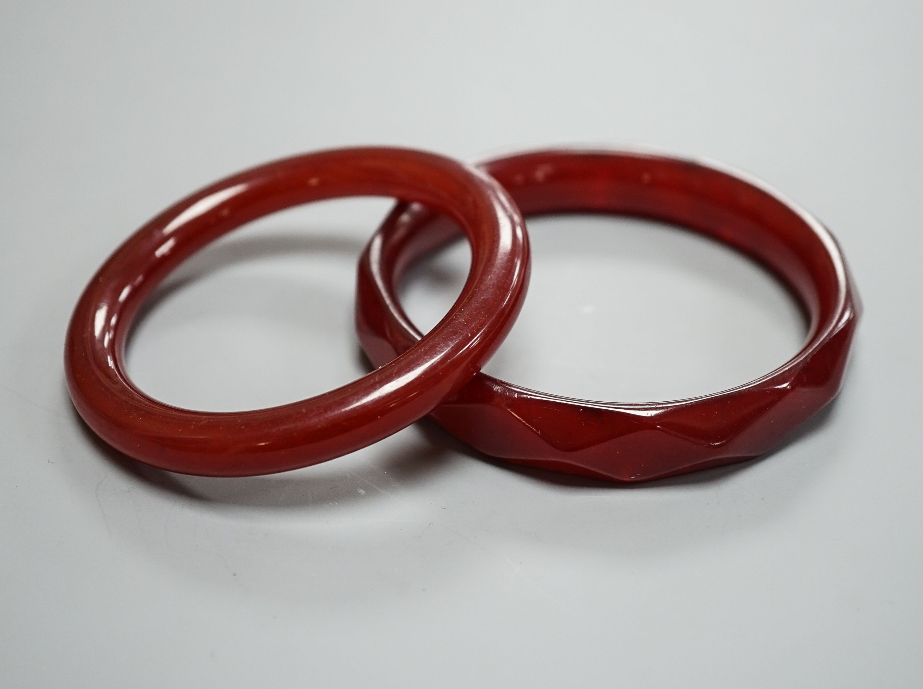 Two cherry amber bangles, gross weight 53 grams.